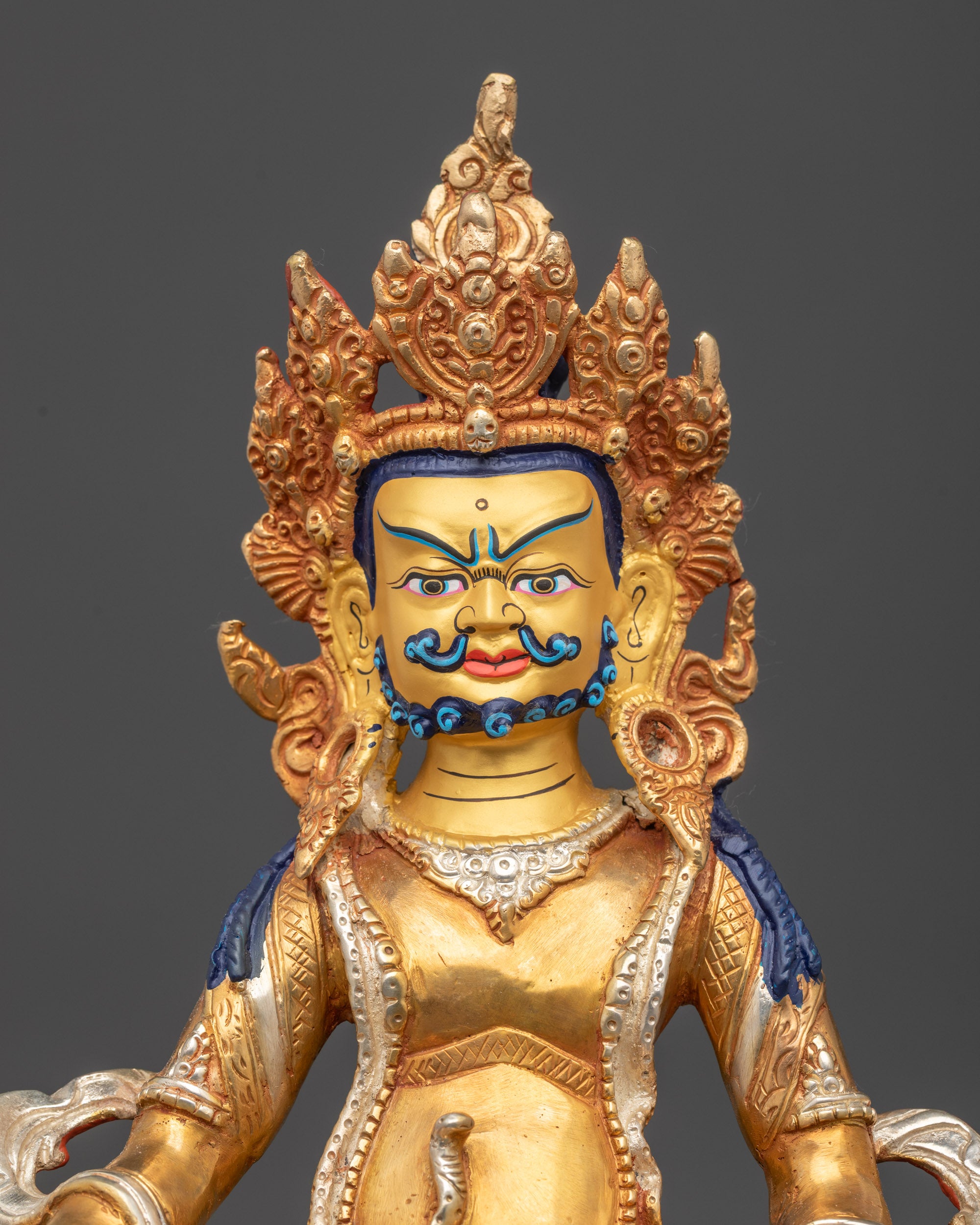 Regular close up of Yellow Dzambhala Statue showing crown, earrings, and flowing robes
