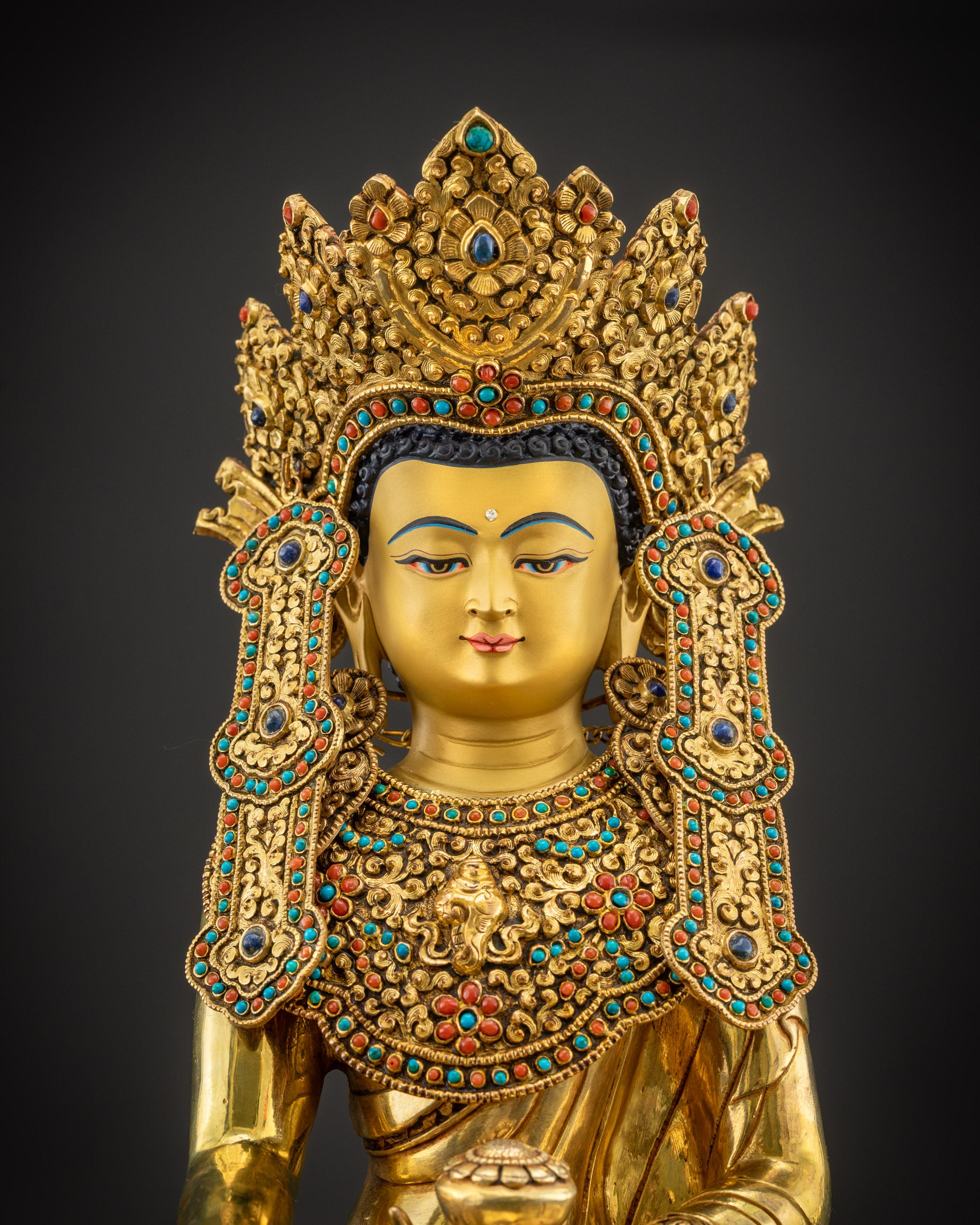 Regular close up of gold-gilded face of sacred Jowo Rinpoche Buddha

