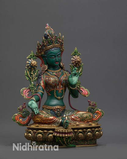 Regular side view Green Tara statue showing flowing robe, gold-gilded details, and lotus seat
