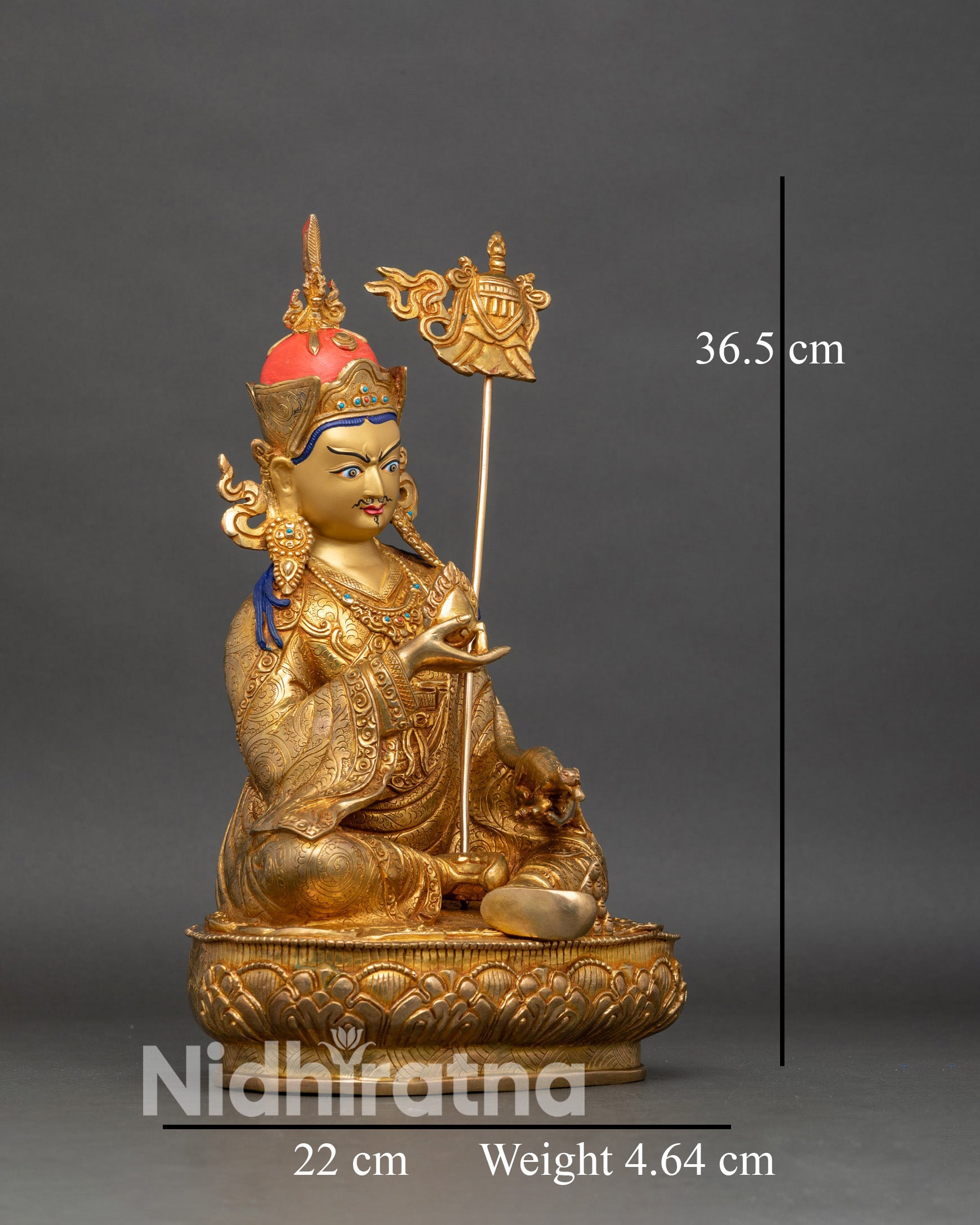 Right profile of Guru Norlha statue holding chintamani and trident on shoulder