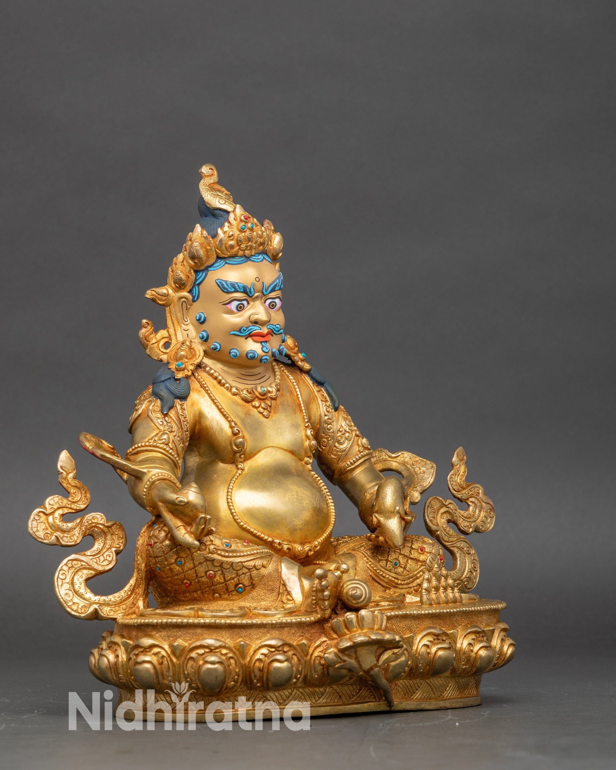 Right side view of Dzambhala statue, seated on lotus pedestal with auspicious motifs