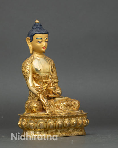 Right-side view of Medicine Buddha statue, seated on lotus, holding myrobalan vase and stem