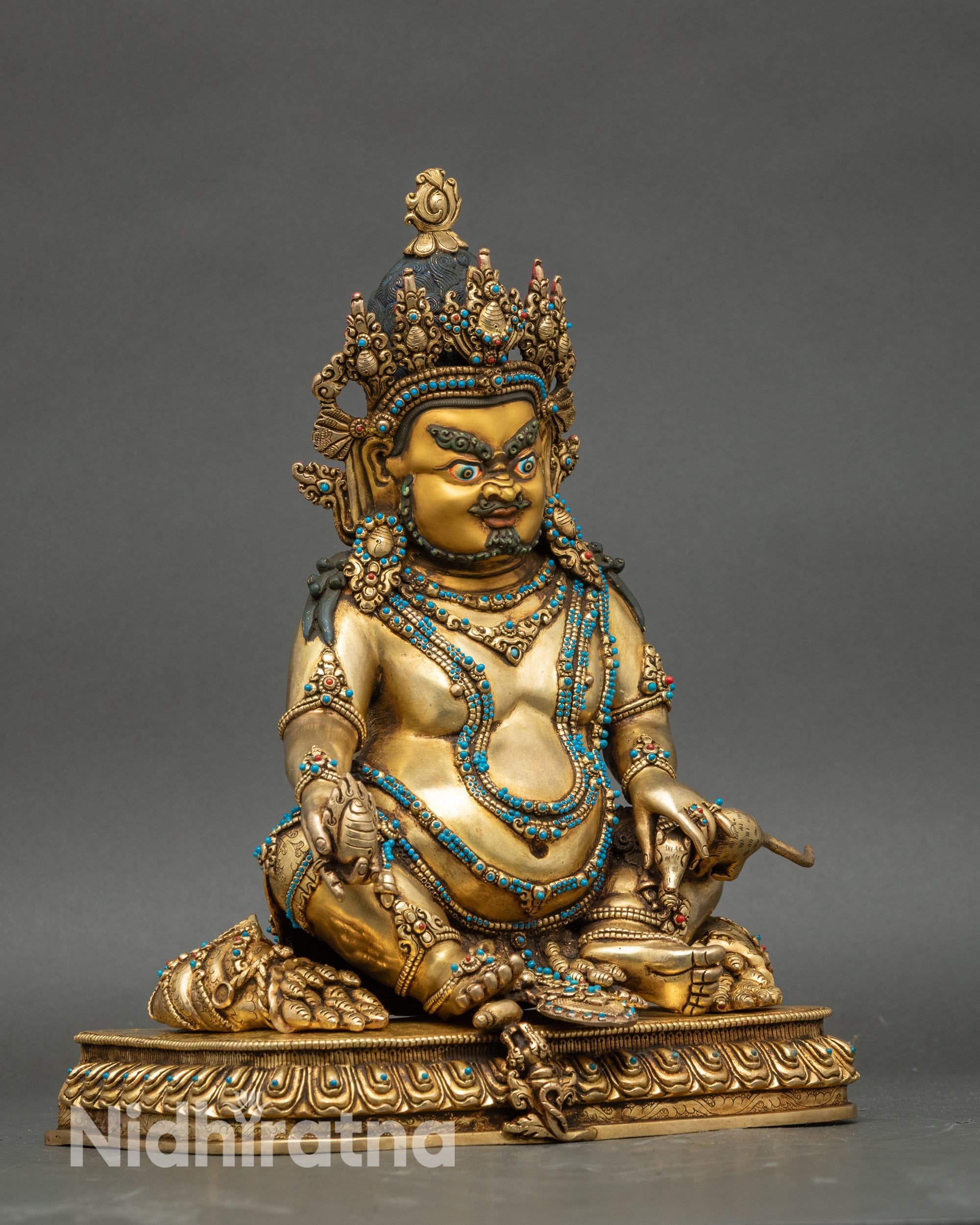 Right profile of Dzambhala statue adorned with jewels, radiating sacred prosperity