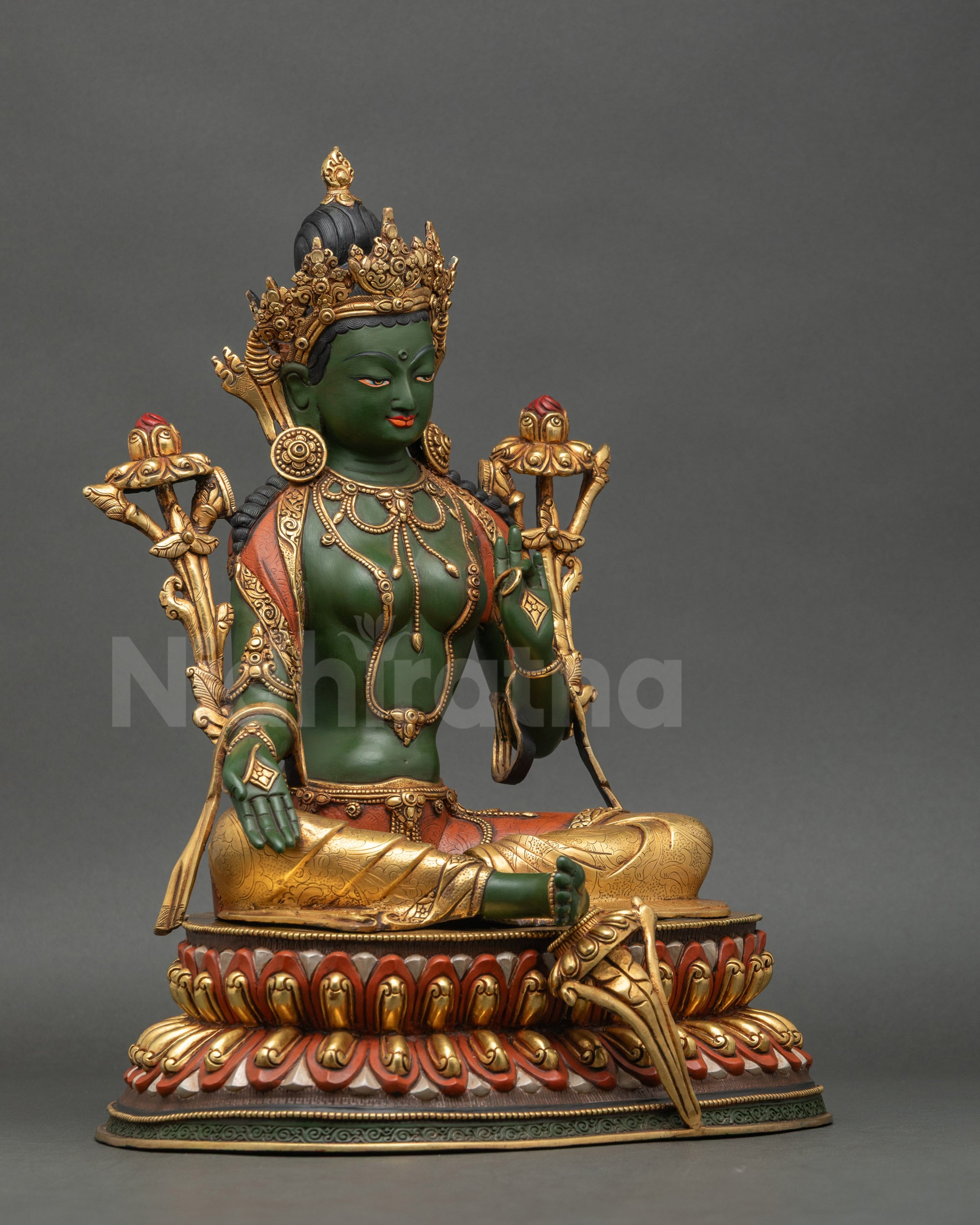 Right side view of vibrant Green Tara sculpture with symbolic utpala lotus flowers