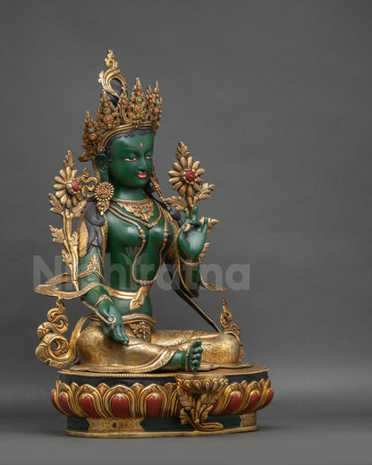 Right view side Green Tara statue showing lotus base and one foot on blooming lotus