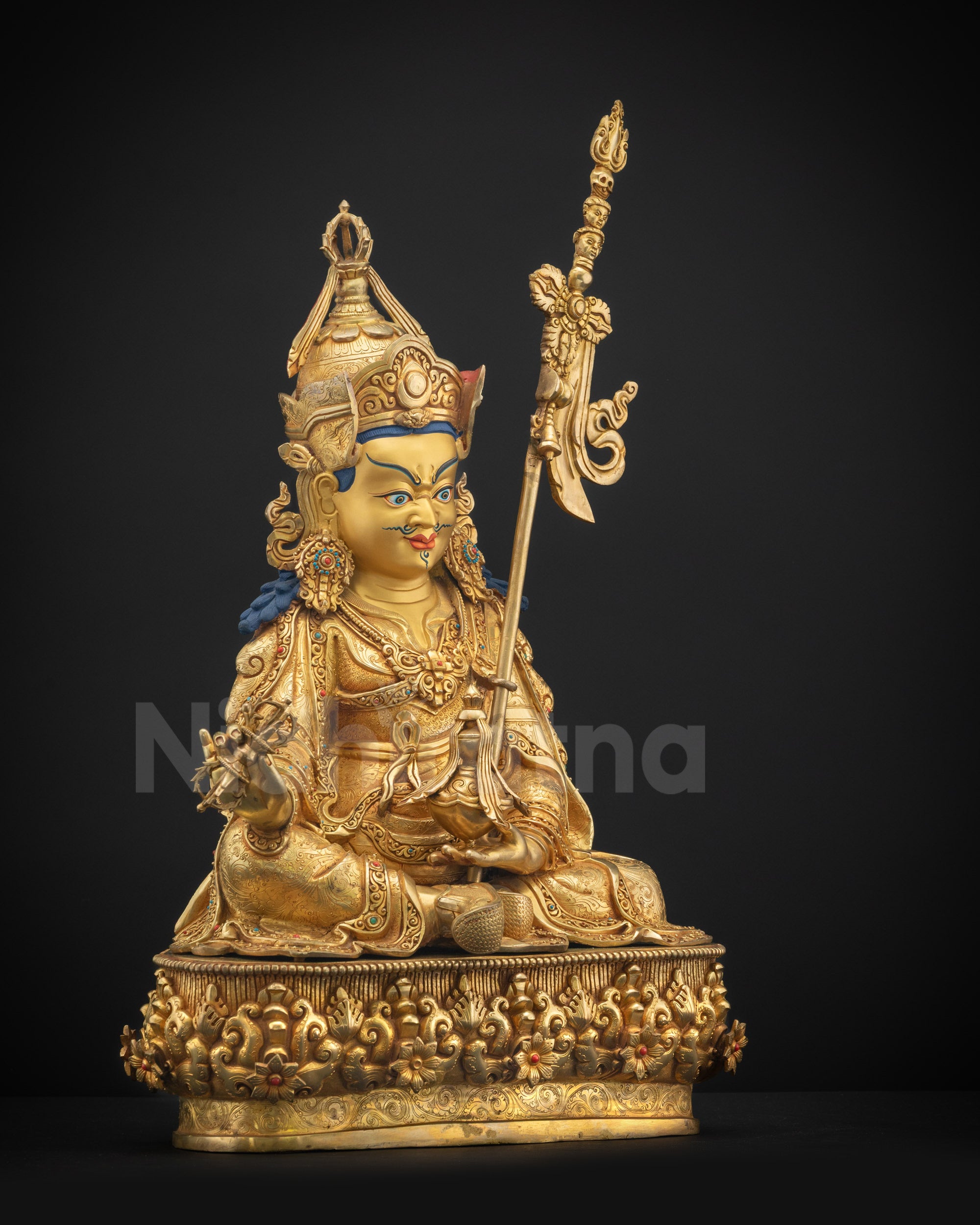 Right view side Guru Rinpoche statue with khatvanga resting on shoulder