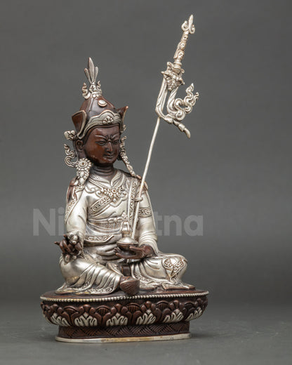 Right view side oxidized Guru Rinpoche copper statue with khatvanga staff on shoulder