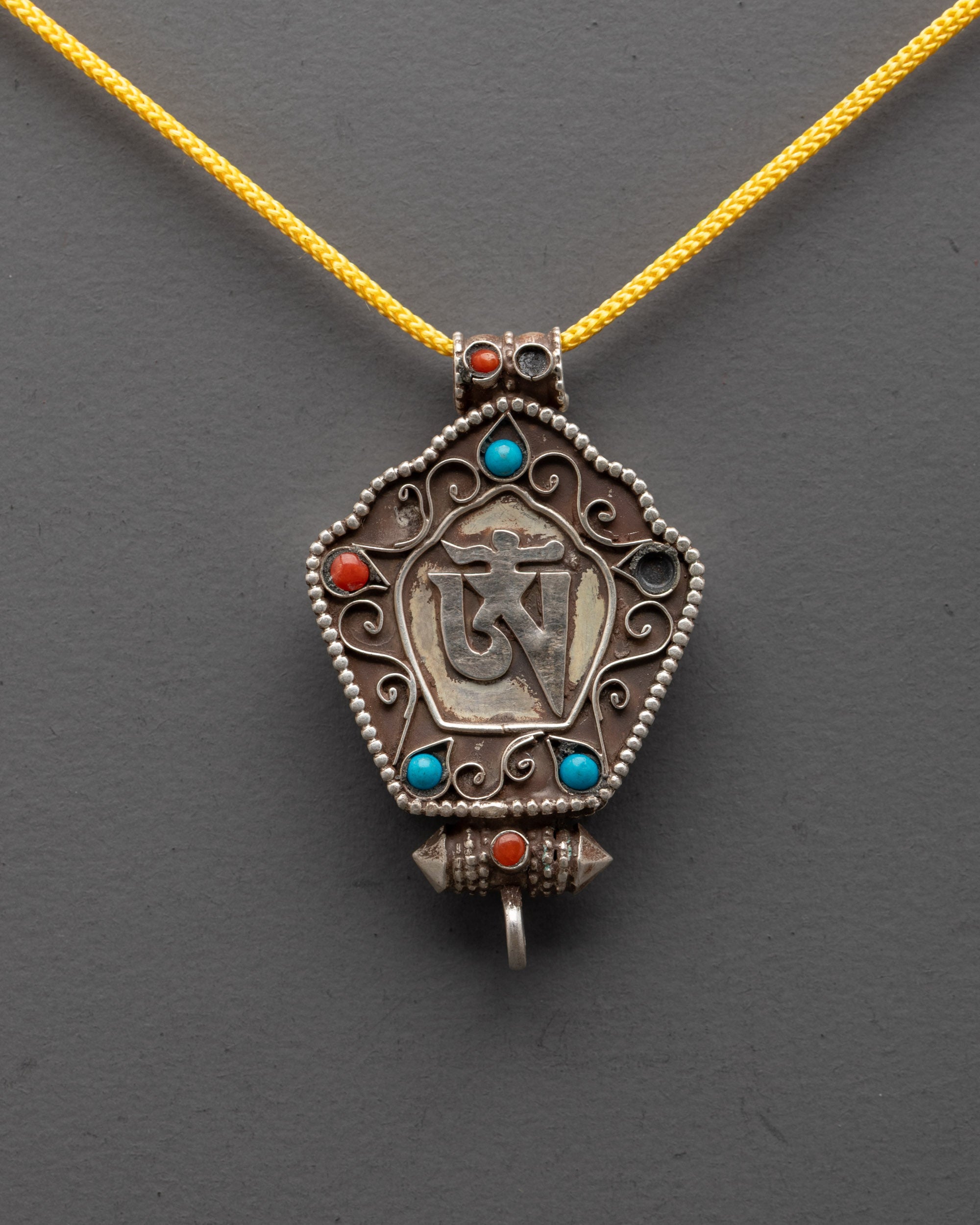 Close-up of Om Symbol Pendant showing silver Om and semi-precious stone details
