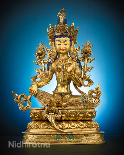 A traditionally hand-carved Goddess Green Tara statue seated in a meditative lotus posture, adorned with semi-precious gemstones and 24k gold plating, symbolizing compassion and enlightenment.