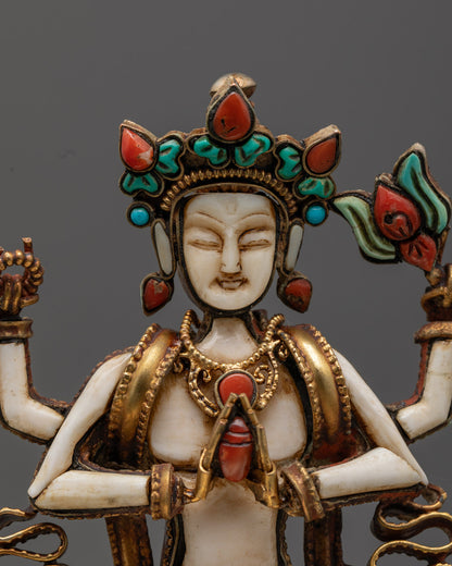 Serene face of Chenrezig Buddha statue with turquoise and coral inlays, radiating compassionate energy