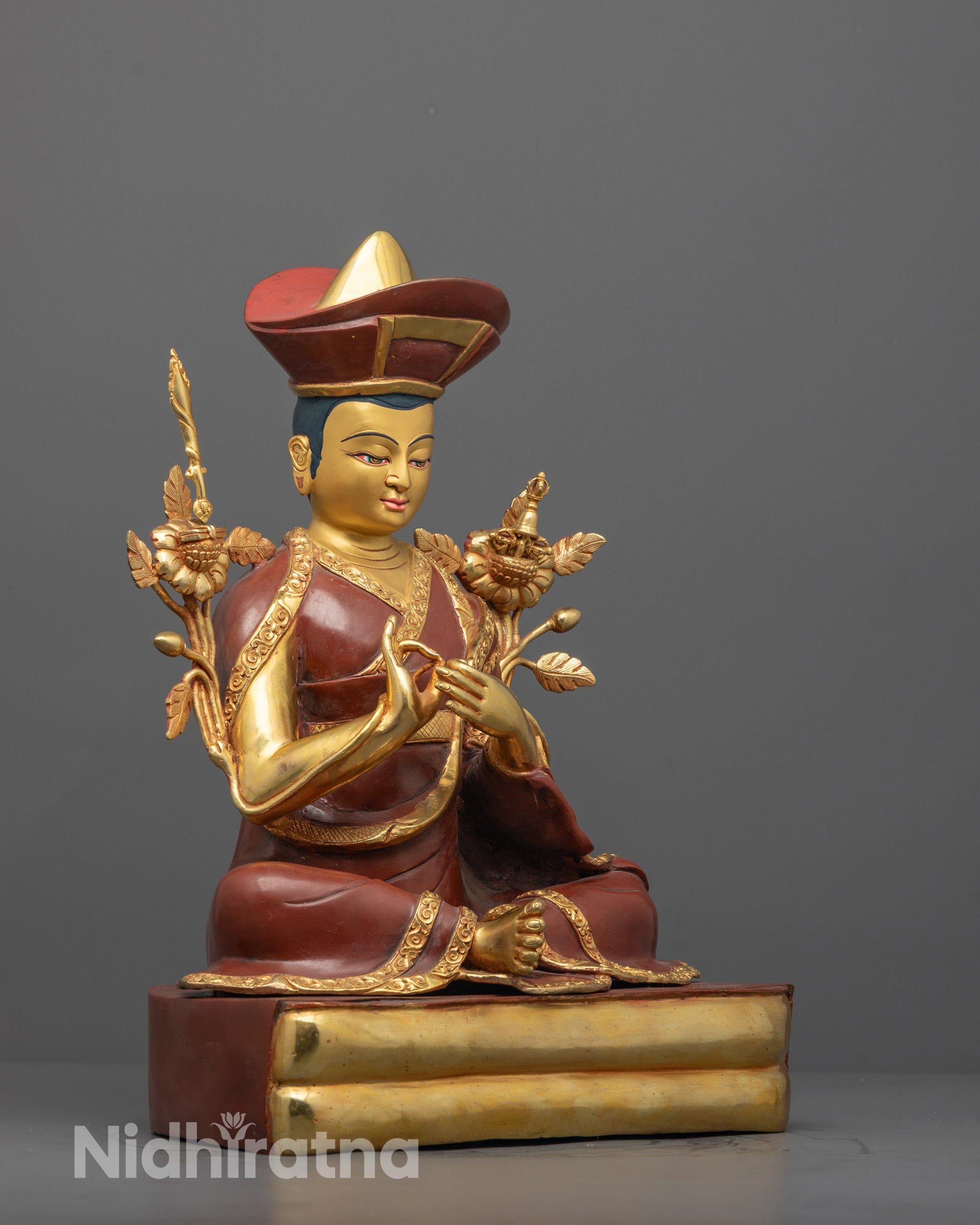 side view of nyamme sherab gyaltsen statue in lama robe with ceremonial hat and calm expression