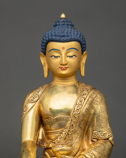Close-up of Buddha statue showing gold-painted face and intricate robe carvings.