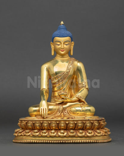 Front view of gold-gilded Shakyamuni Buddha statue seated on lotus pedestal