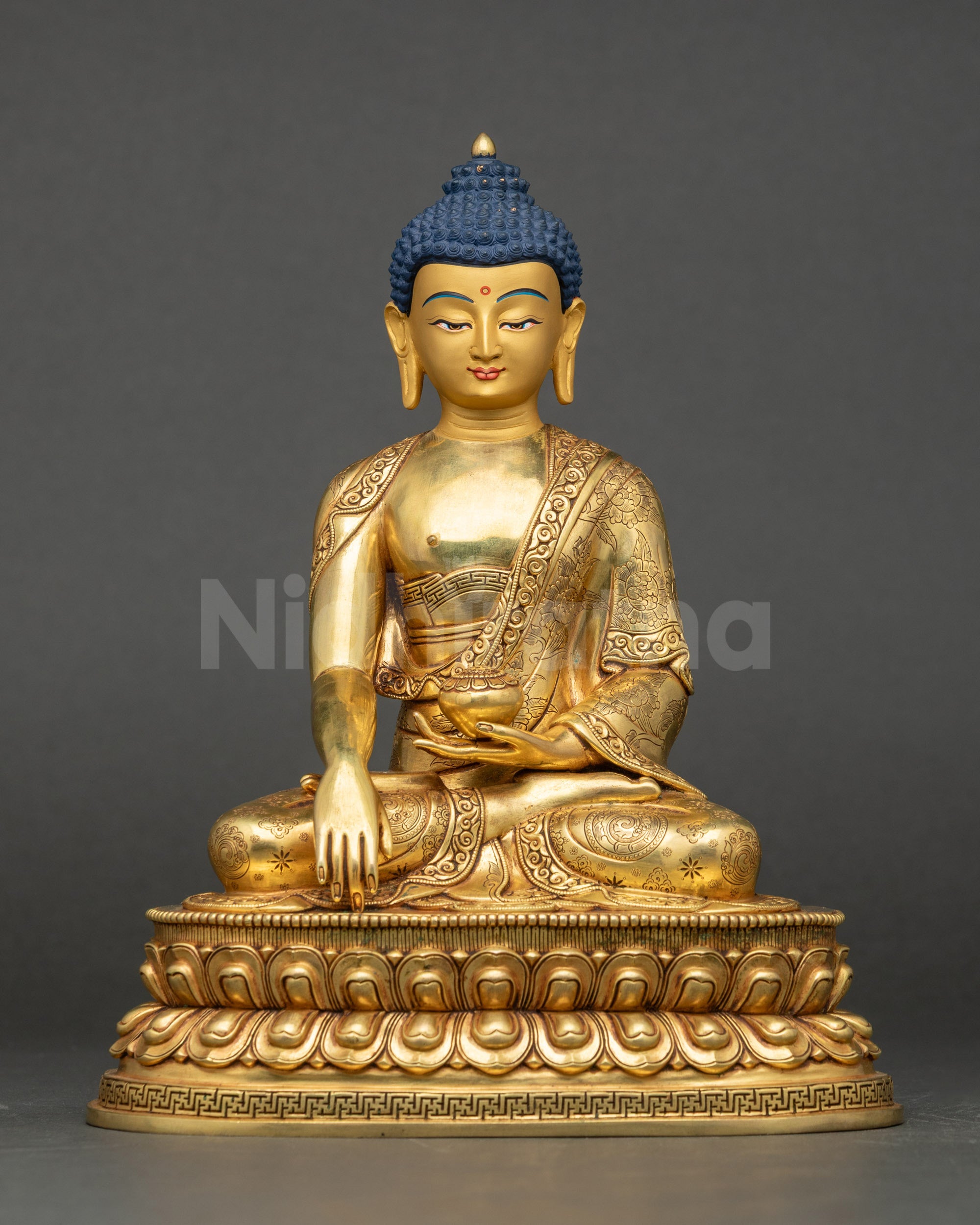 Front view of Shakyamuni Buddha Statue, gold-gilded, seated on lotus with patra bowl.