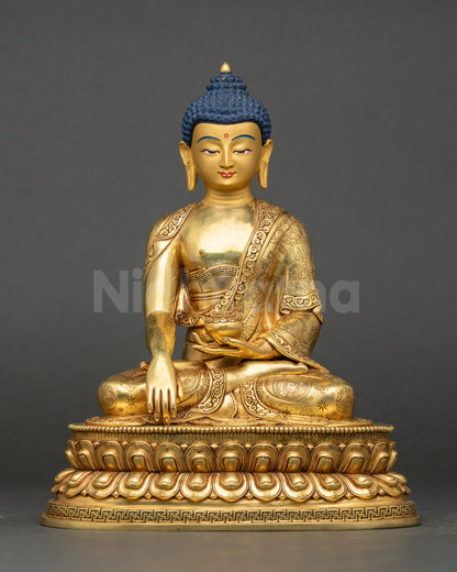 Front view of Shakyamuni Buddha Statue, gold-gilded, seated on lotus with patra bowl.