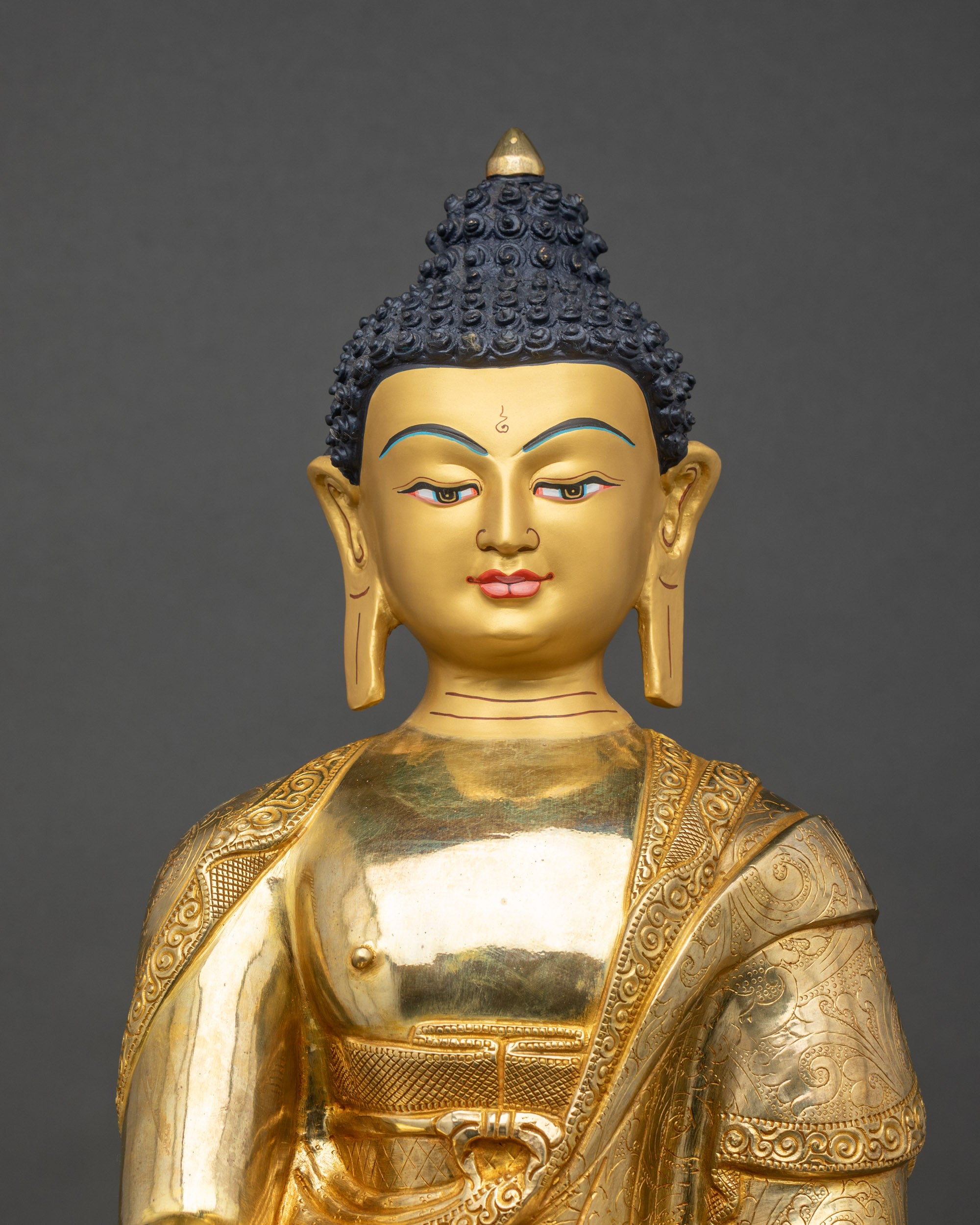Shakyamuni Buddha Statue close-up, intricate robes and hand-carved details in gold