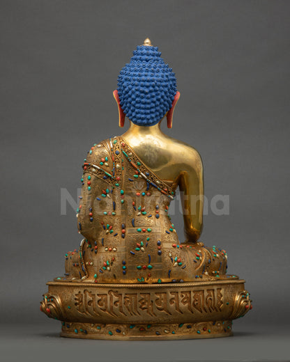 Back view of Shakyamuni Buddha statue showing detailed carvings on robe and posture