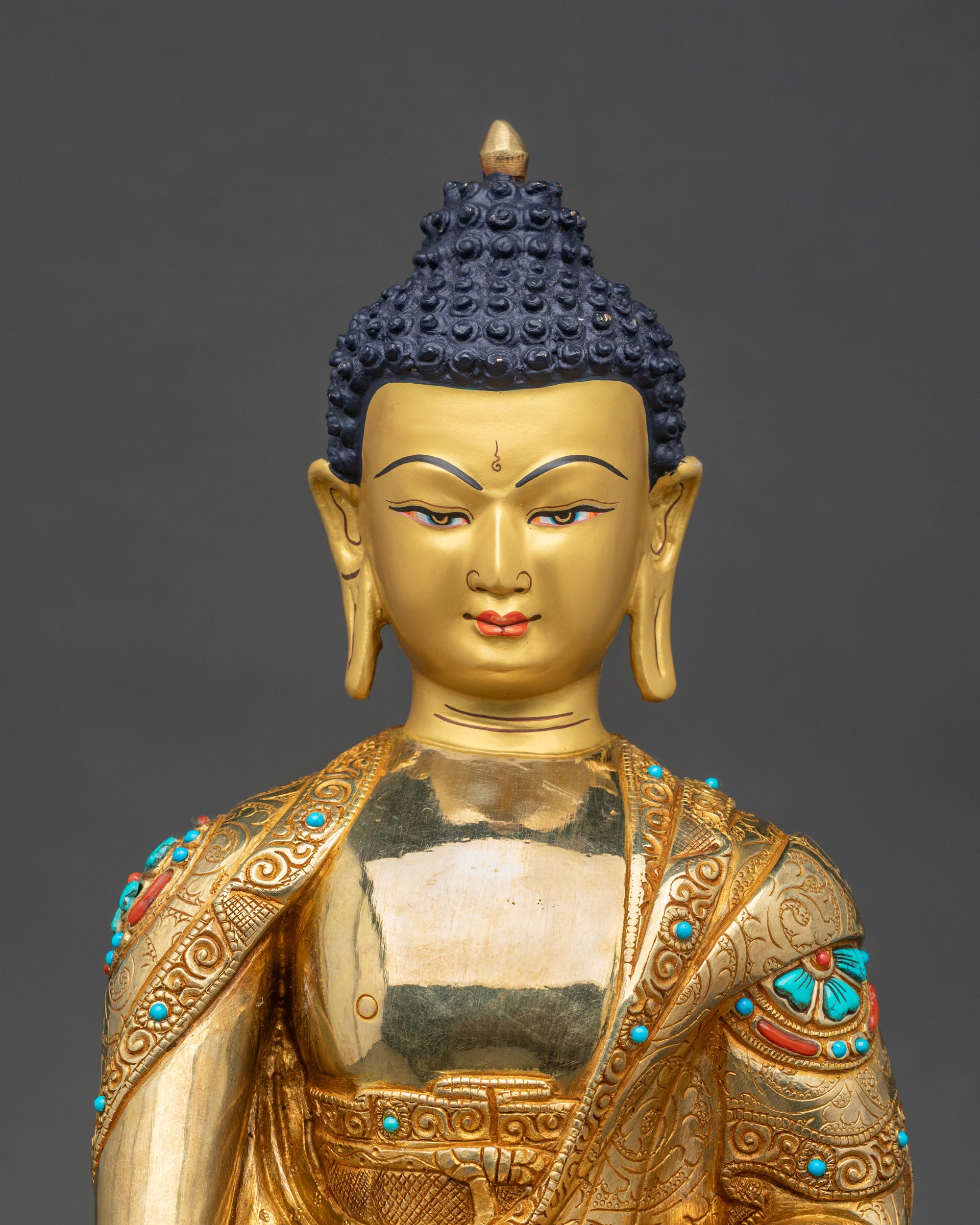 Shakyamuni Buddha statue close up with turquoise coral inlaid robes and lotus pedestal details