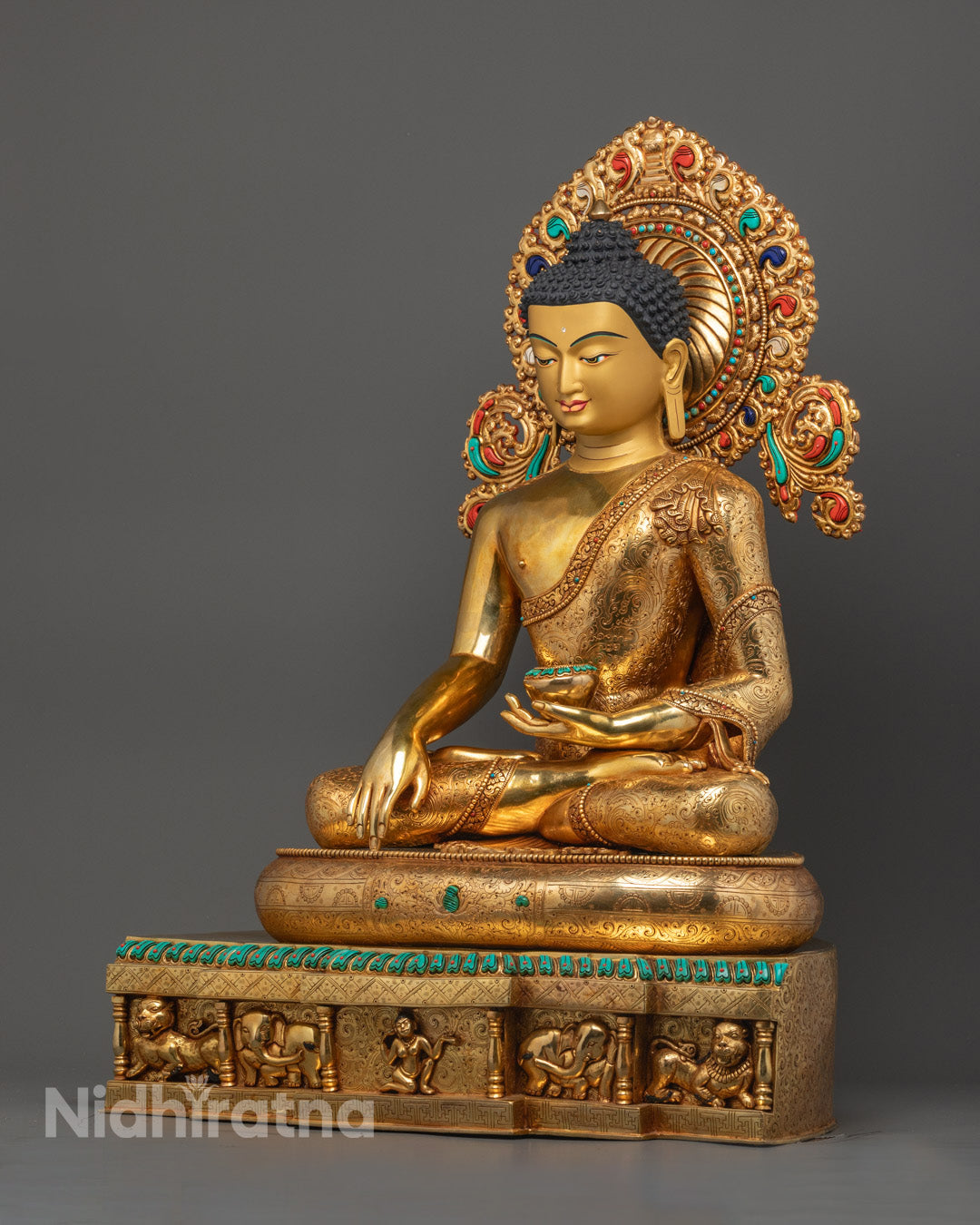 Shakyamuni Buddha statue holding a patra alms bowl inlaid with semi-precious stones, symbolizing renunciation and compassion