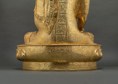 Side angle view of gold gilded Buddha statue on lotus pedestal base