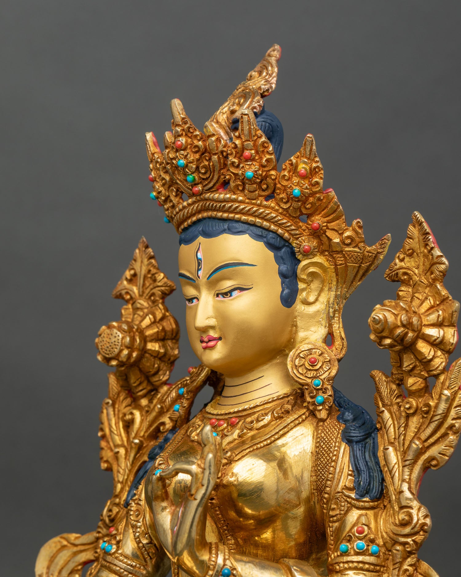 Side close-up of White Tara statue highlighting ornate lotus seat and flowing robes
