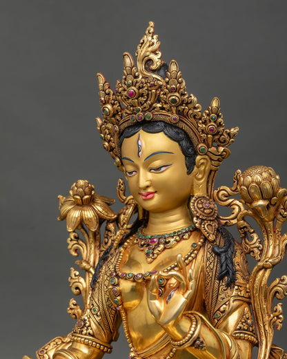 Side close up of hand-carved gold gilded White Tara statue with jeweled crown and lotus