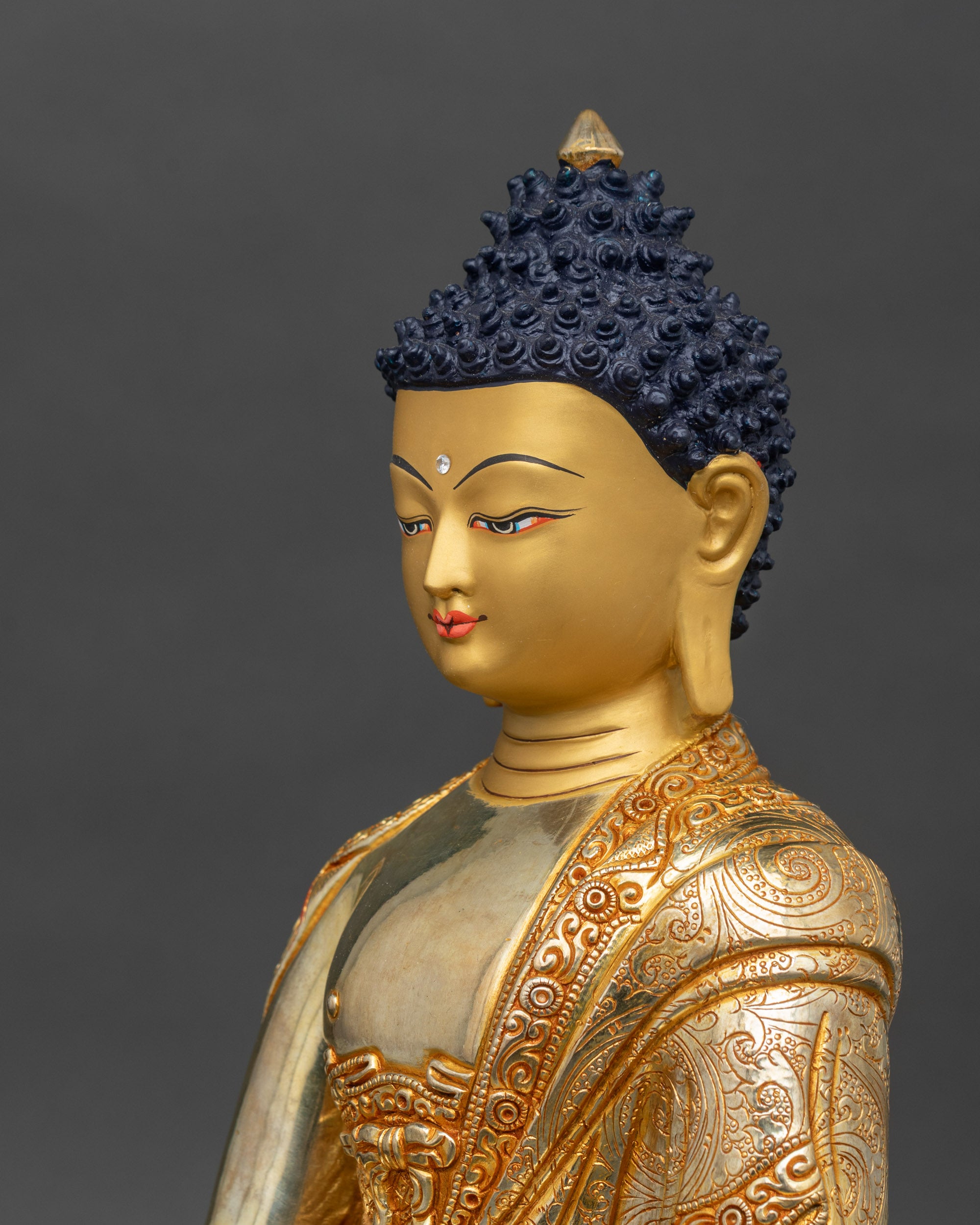 Side view close-up of Shakyamuni Buddha statue highlighting engraved robe and lotus seat