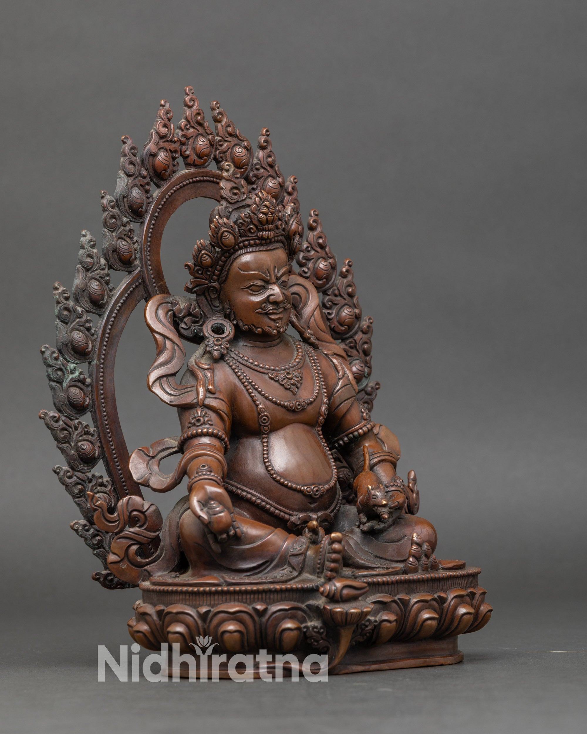 Side view of Dzambhala statue showing ritual staff and trident, handcrafted in Patan