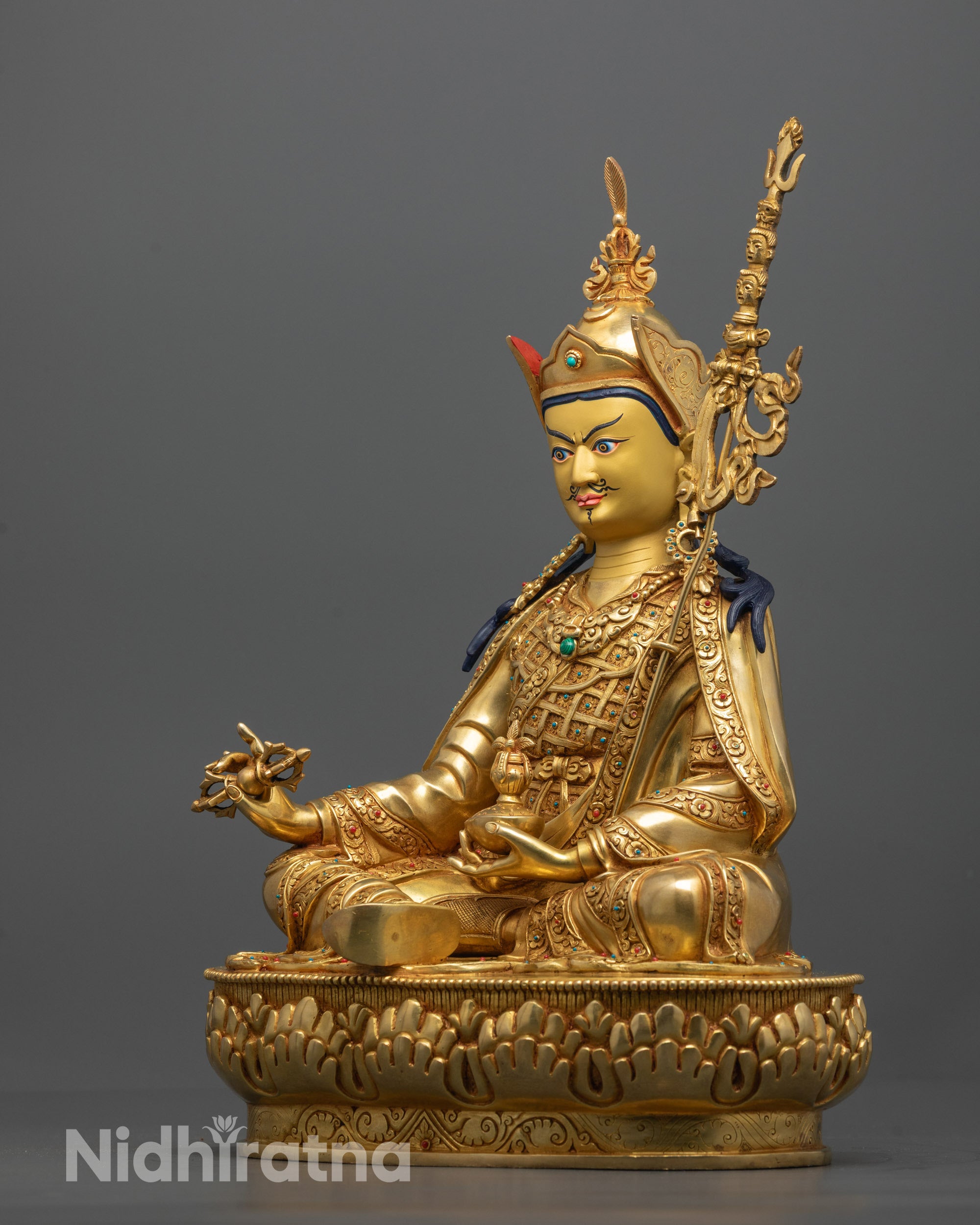 Side View of Guru Rinpoche Statue Showcasing Detailed Robes and Sacred Implements