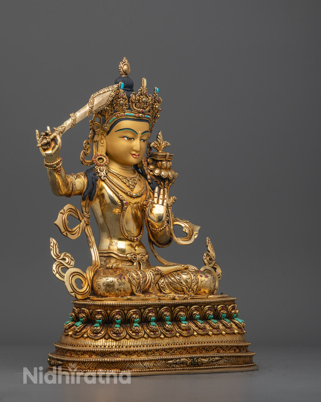 Side angle Tibetan Manjushri Bodhisattva Sculpture showing robe carvings and utpala flower