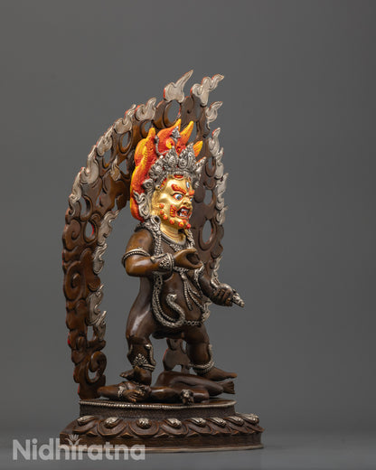 Side angle of Black Dzambhala Statue with oxidized copper body and silver-plated garments