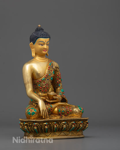 Side angle of Buddha Shakyamuni statue showing gold fire gilded body and alms bowl detail