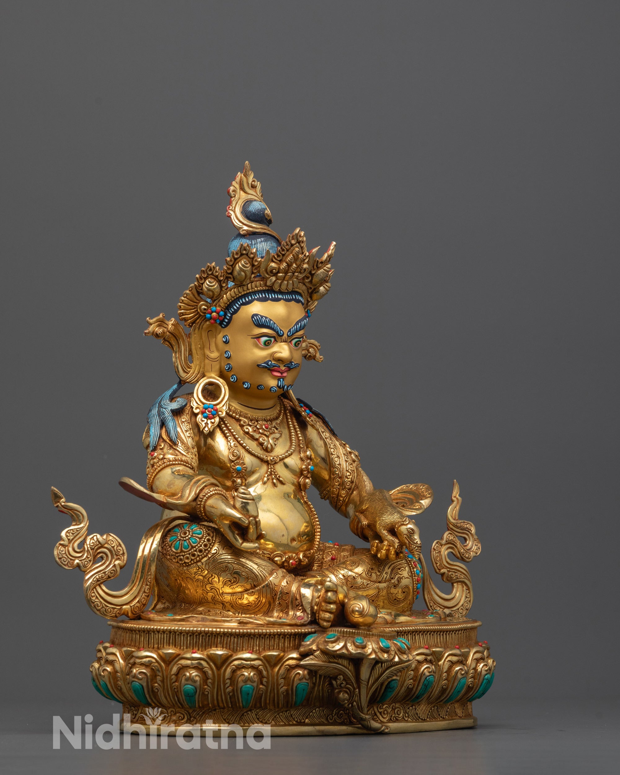 Side angle of Dzambhala statue seated on lotus with one foot on shell in royal ease pose