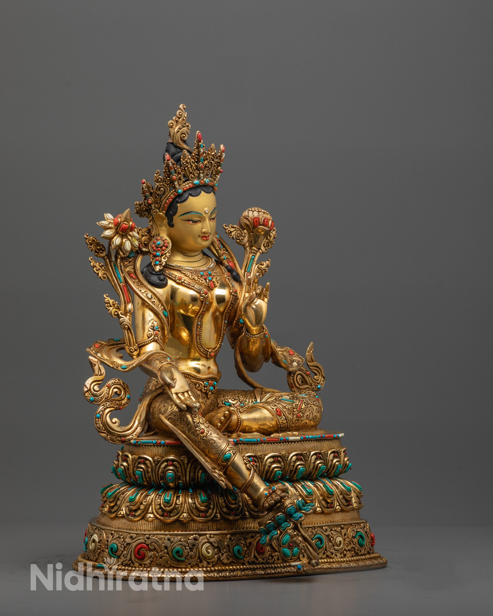 Side angle of Green Tara seated on double-layered lotus throne with five-jeweled crown
