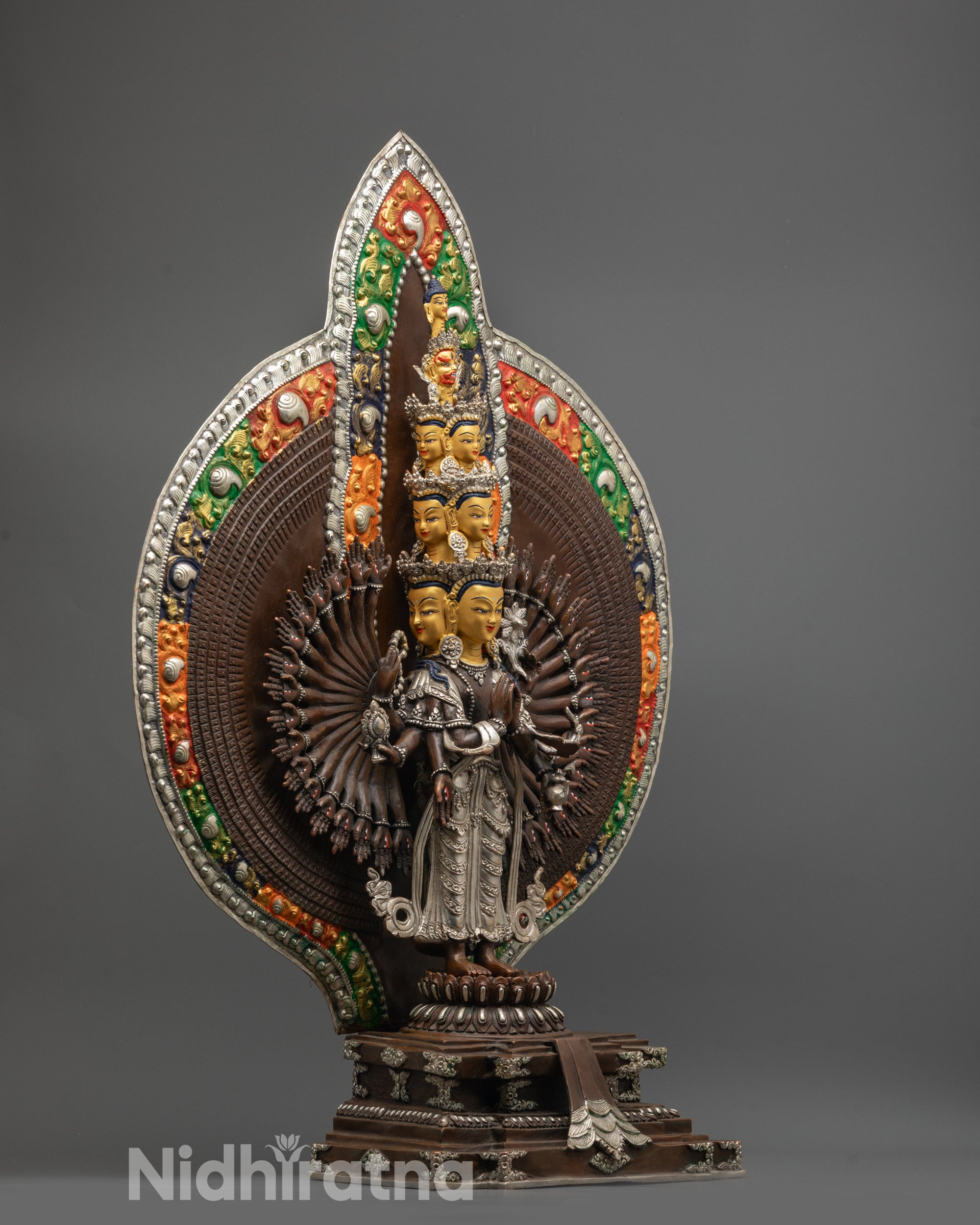 Side angle of Guan Yin statue with thousand arms and acrylic-colored halo motifs