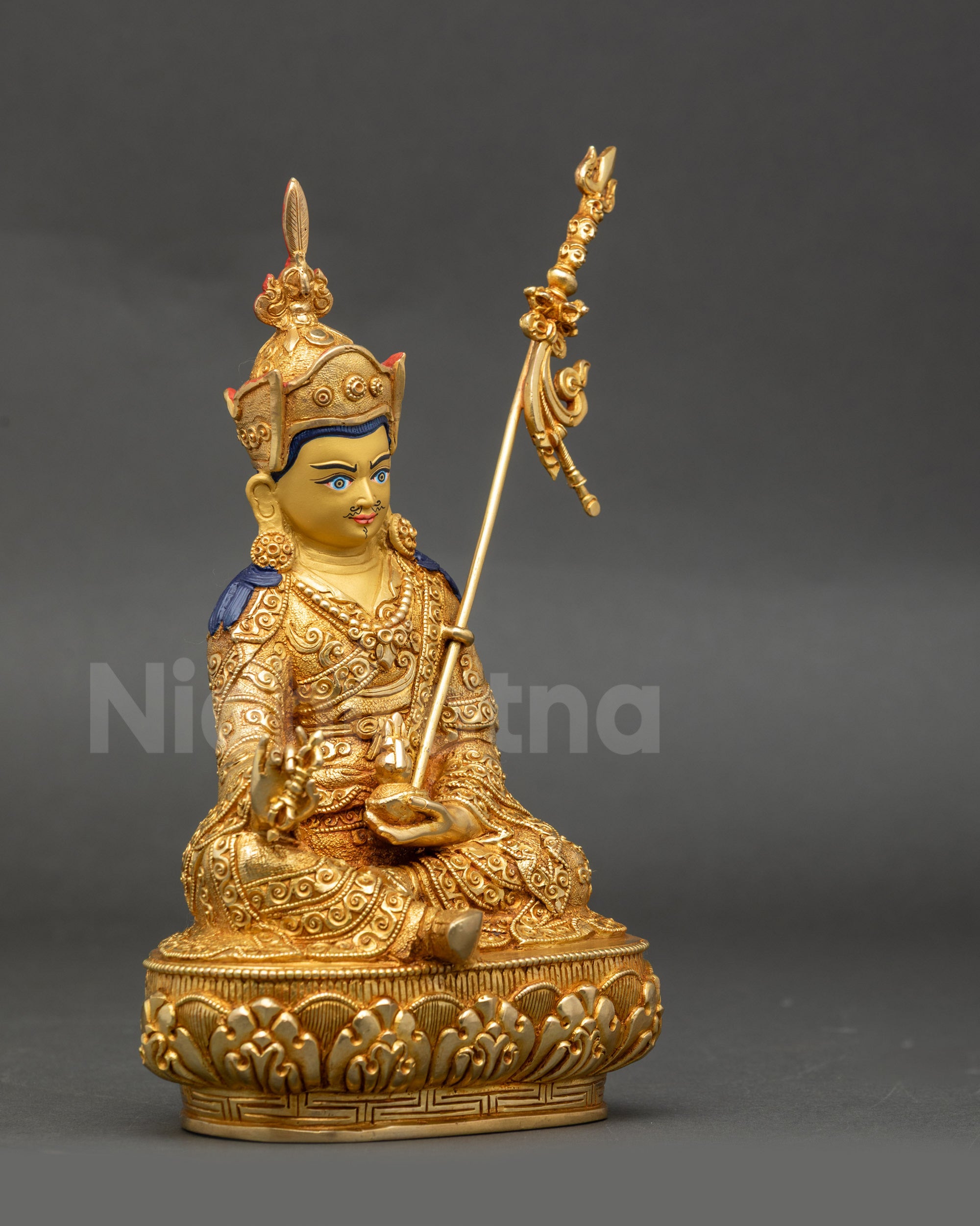 Side angle of Guru Rinpoche statue showing trident and ornate lotus crown