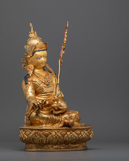 Side angle of Himalayan Guru Rinpoche sculpture showing Khatvang trident and robe folds