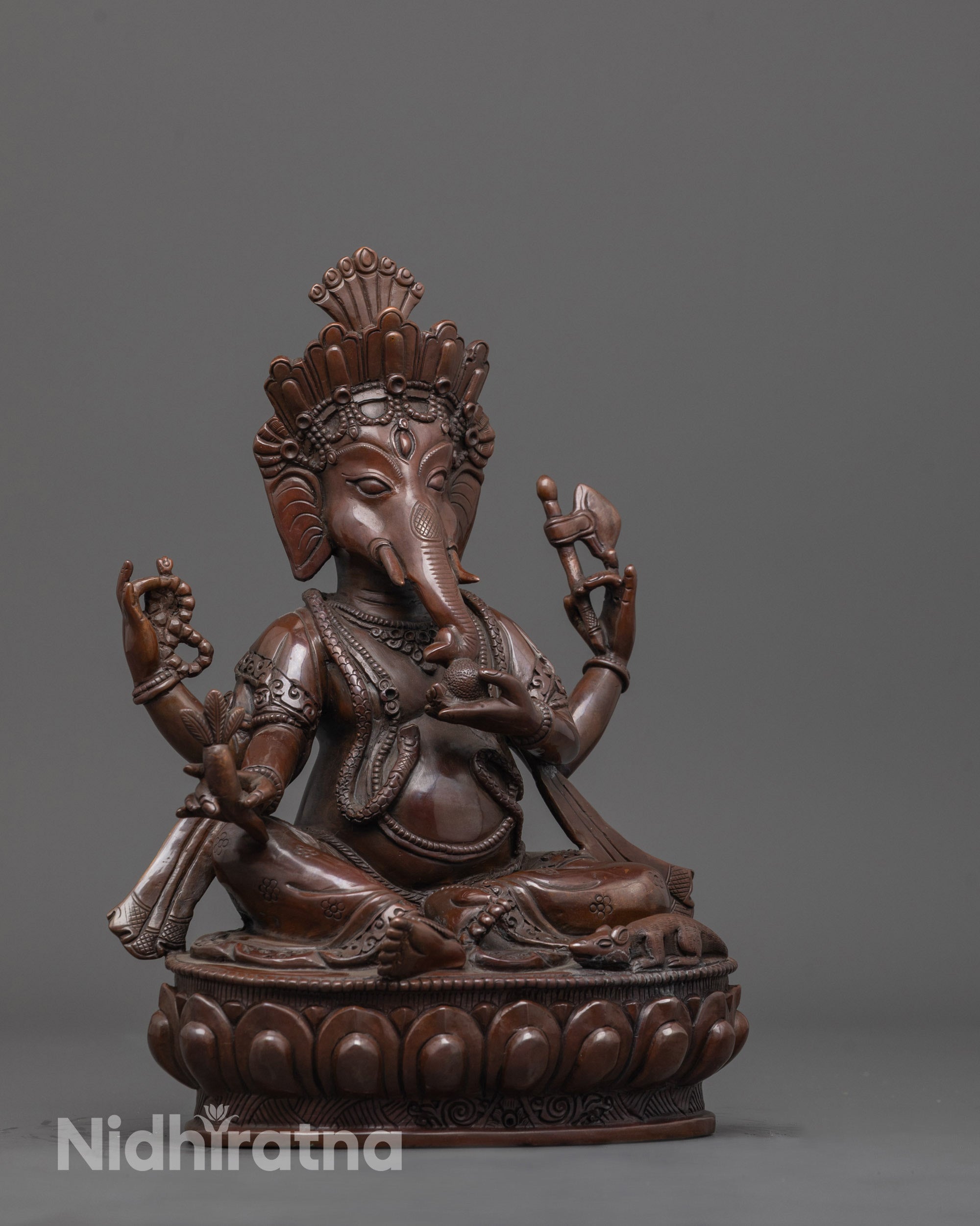 Side angle of Lord Ganesha statue with axe, rosary, and Mushika vehicle near feet visible.