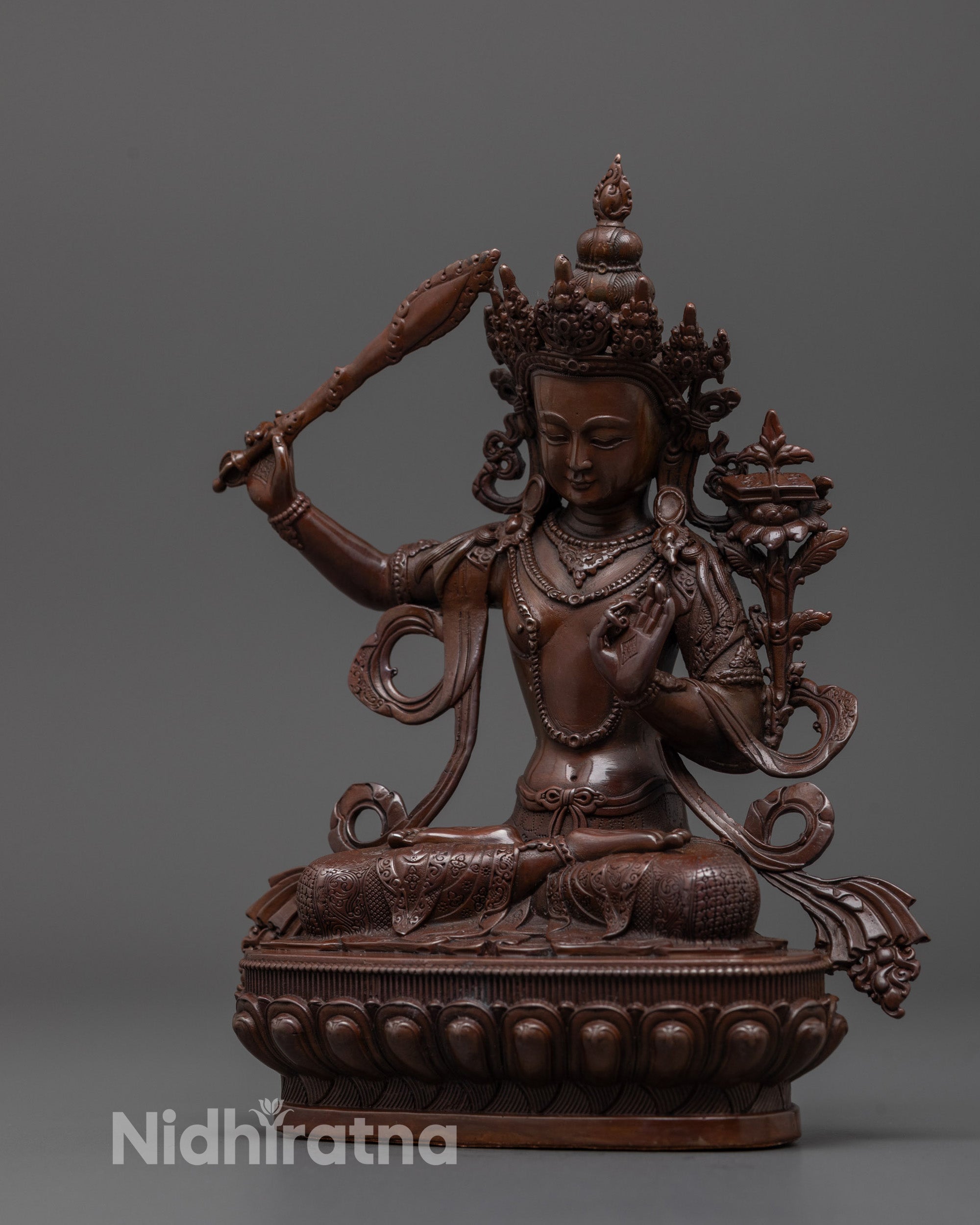 Side angle of machine-made Manjushri statue holding utpala flower and blessing mudra pose