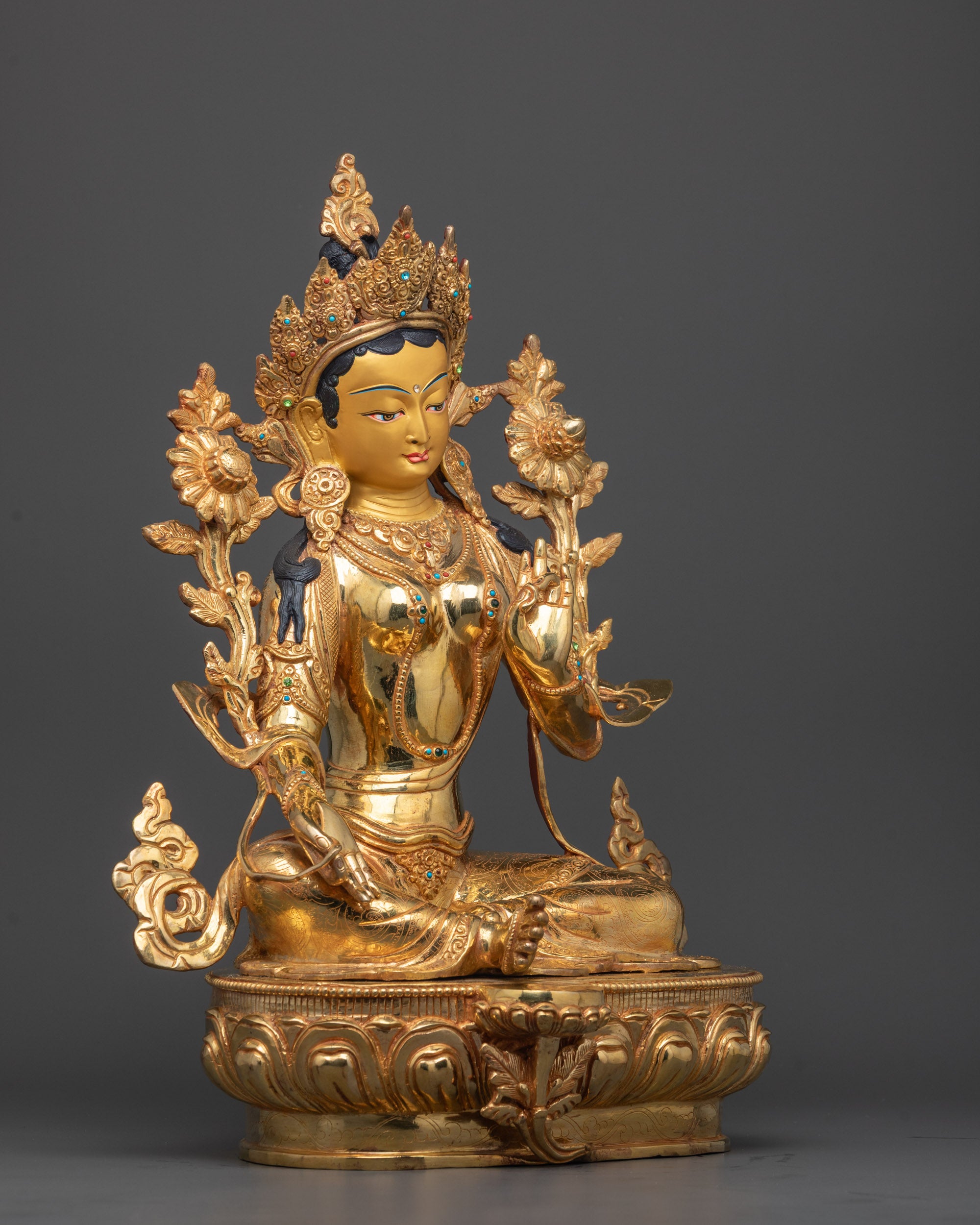 Side angle of Mother Tara Sculpture showing detailed utpala flower and flowing robe