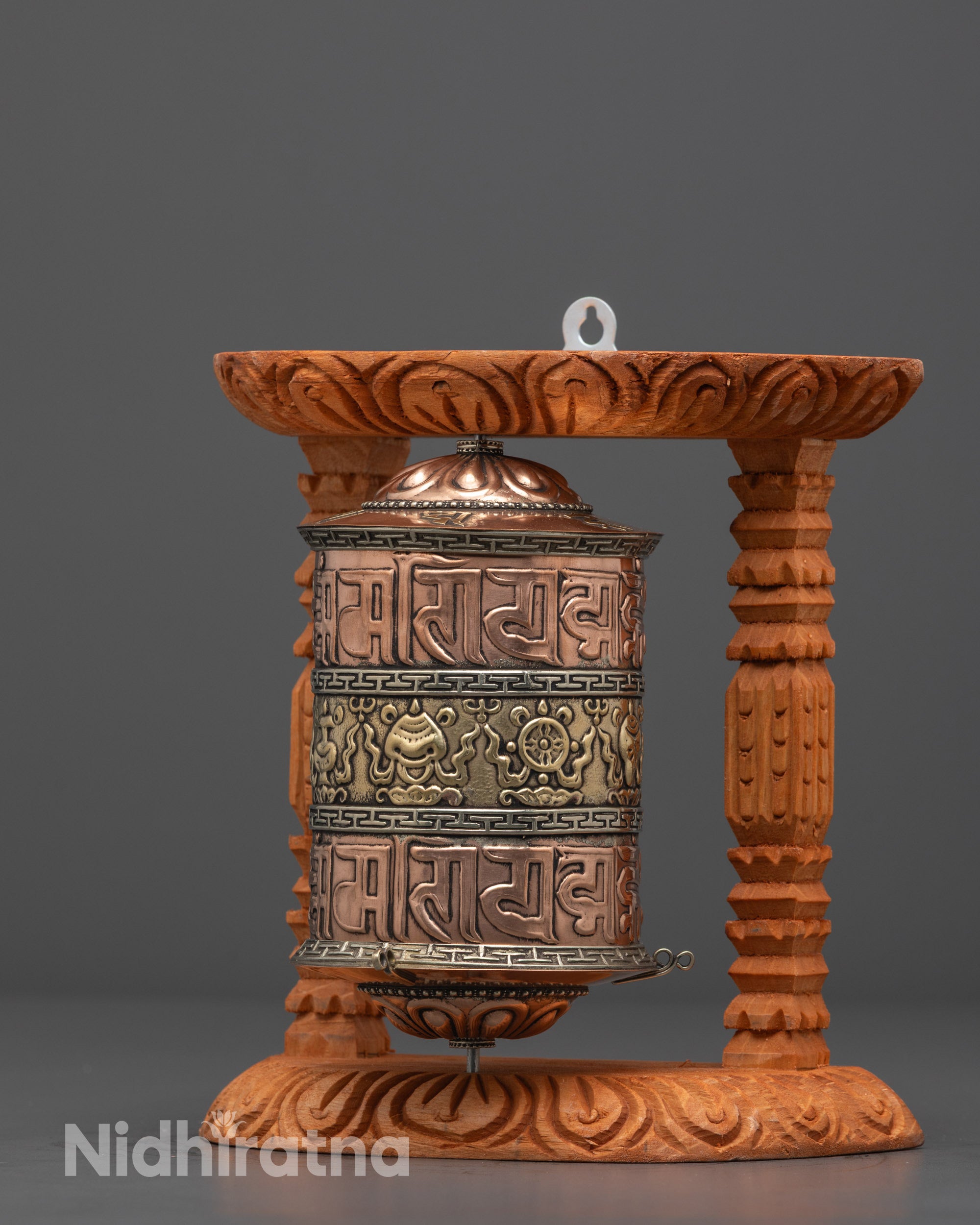 Side angle of Tibetan Prayer Wheel highlighting brass and carved wooden frame details