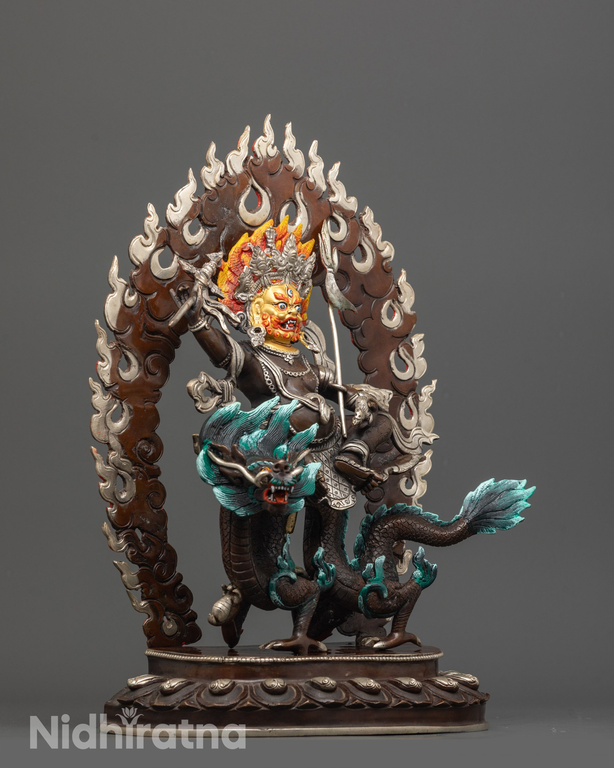 Side angle of White Dzambhala seated on painted Dragon Kubera with shells in its claws.