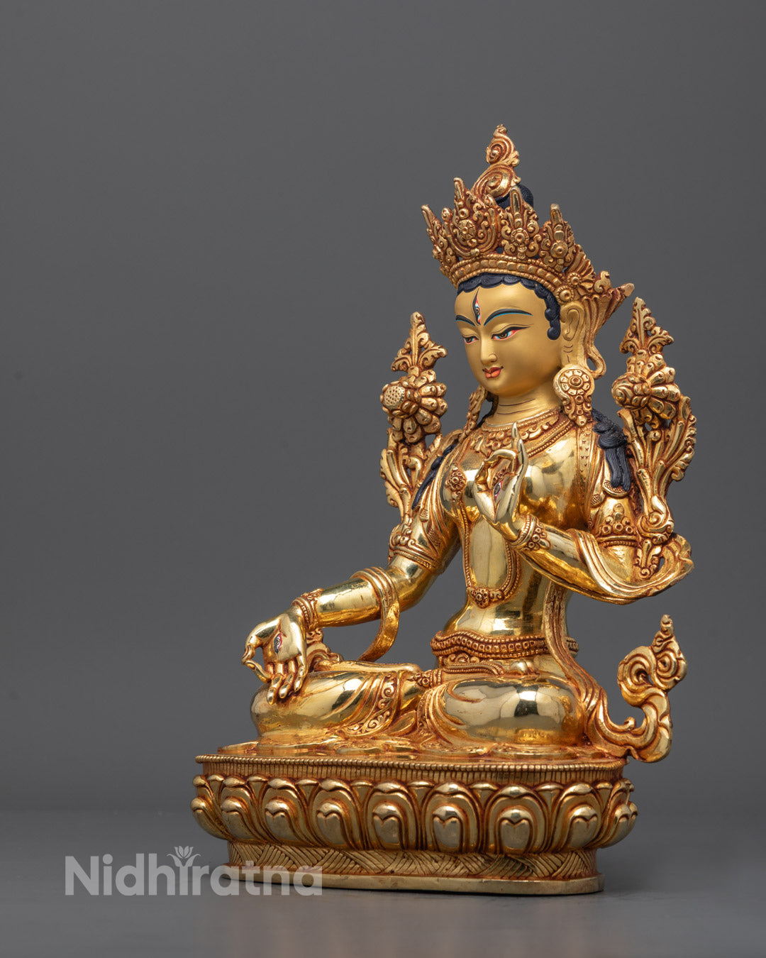 Side angle of White Tara Sculpture holding uptala flower, highlighting flowing robe details