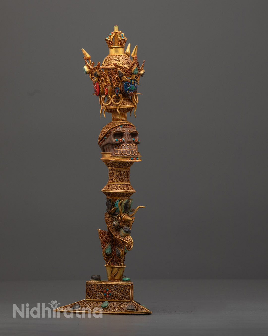 Side angle of copper ritual Phurba showing detailed copper accents and painted designs