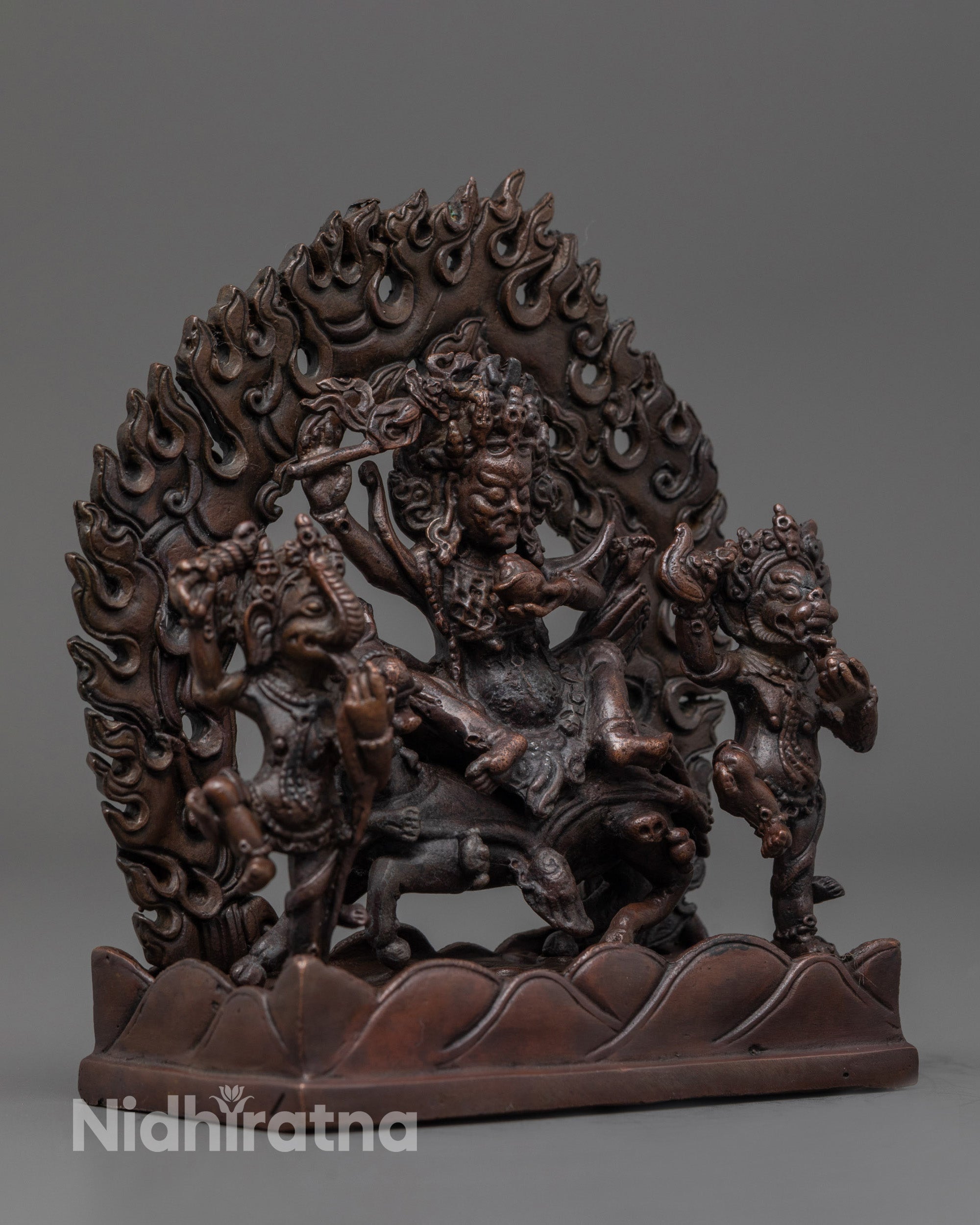 Side angle of fierce Palden Lhamo statue riding her legendary horse with attendant deities
