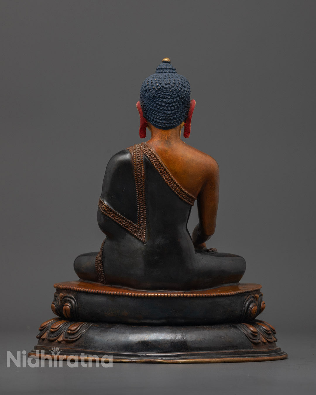 Side angle of handcrafted Buddha statue with oxidized copper finish