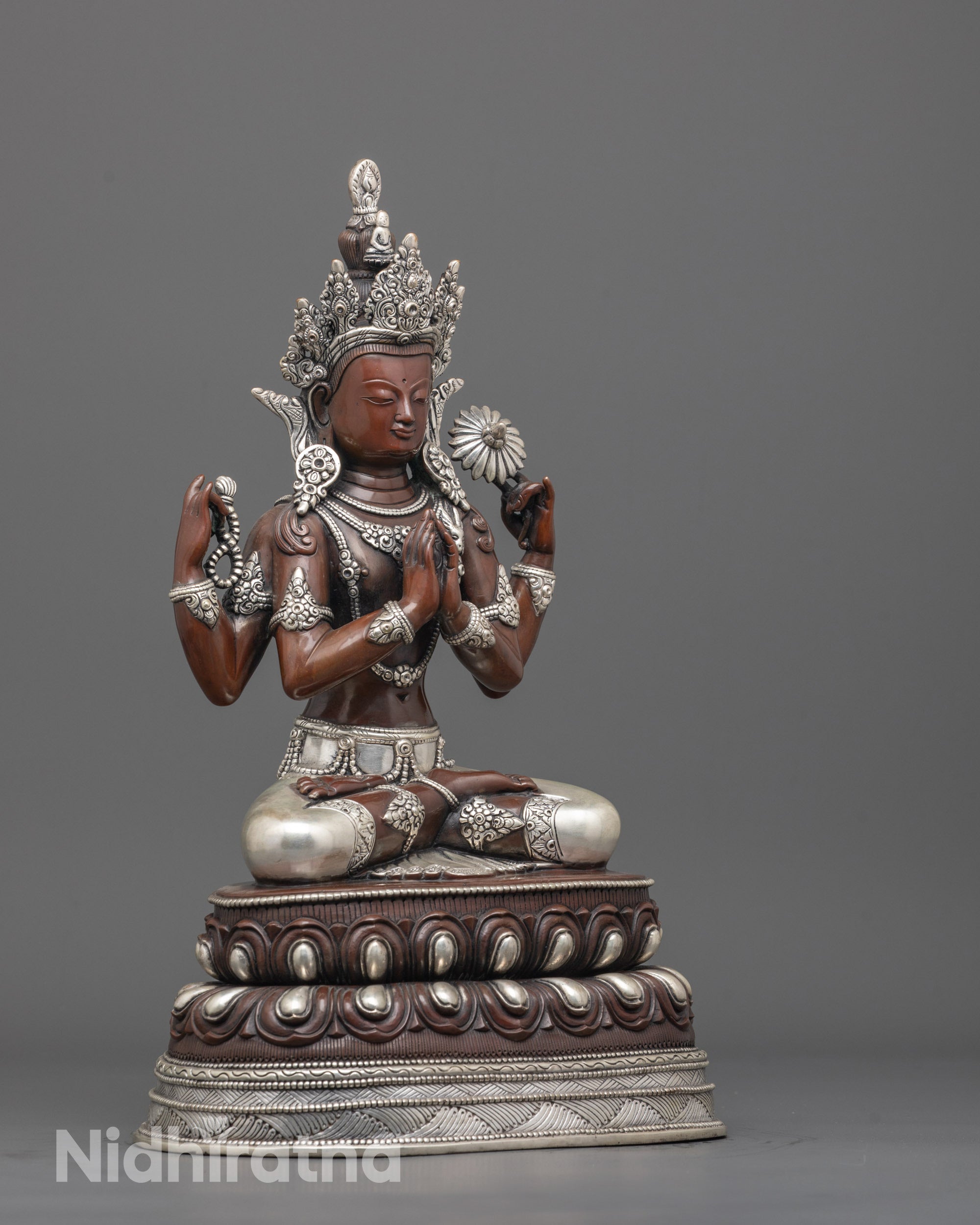 Side angle of handcrafted Chenrezig statue holding mala beads lotus and wish-fulfilling gem
