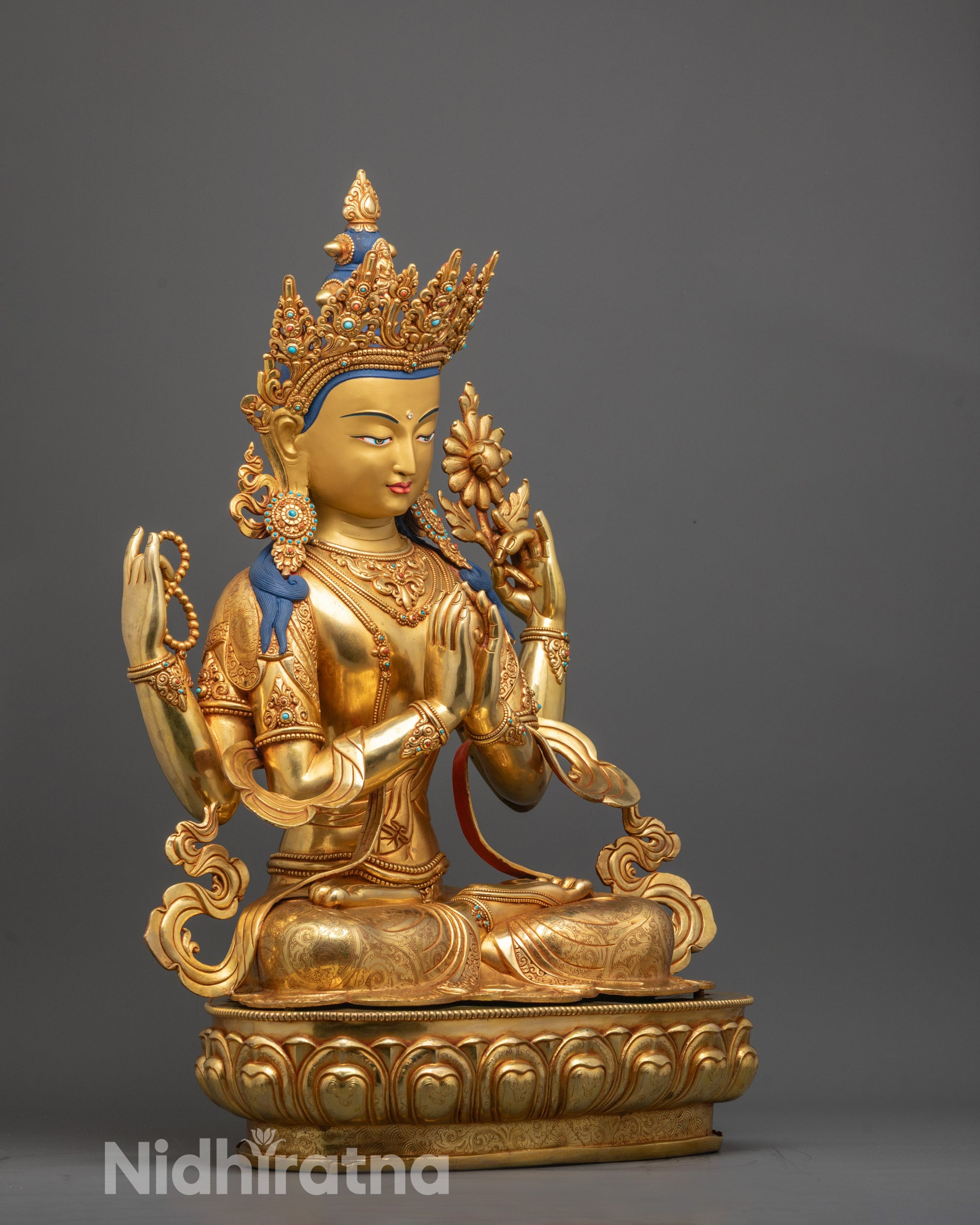 Side angle of handcrafted Chenrezig statue showing flowing robe and deer skin details