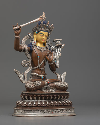 Side angle of handcrafted Manjushri statue showing silver-plated robe and lotus throne