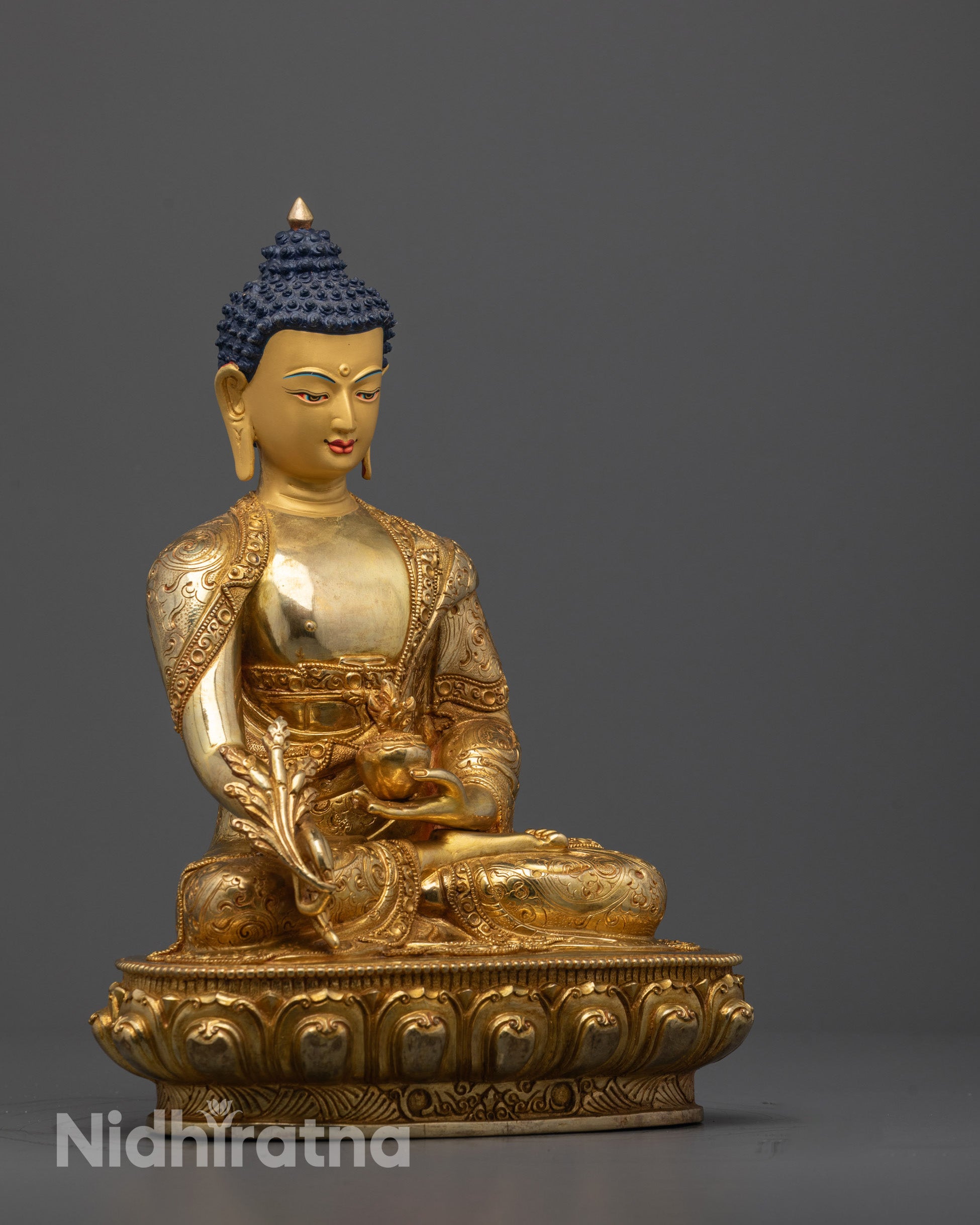 Side angle of handcrafted Medicine Buddha showing robe patterns and lotus seat